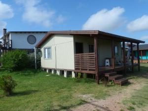 a small house with a porch and a deck at Cabaña I Punta Negra in Piriápolis