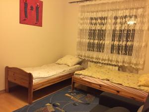- 2 lits jumeaux dans une chambre avec fenêtre dans l'établissement Apartament Wilnianka, à Krynica-Zdrój