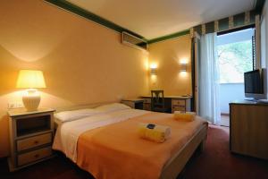a hotel room with a bed and a lamp at Hotel Solitudo in Ubli