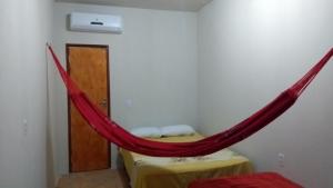 um quarto com uma rede vermelha pendurada na parede em Beach House em Flecheiras