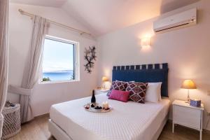 a bedroom with a bed with a table with candles on it at Villas Muscalas by Konnect, 200m from the Beach in Lákka