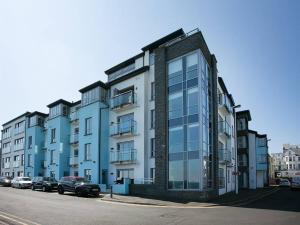 a large building with cars parked in front of it at Blue Pool View in Portrush