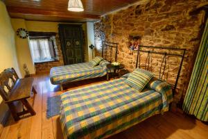 a living room with two couches and a stone wall at Casa do Eiró in Lago de Carucedo