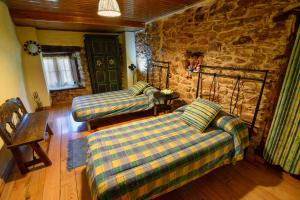 a living room with two couches and a stone wall at Casa do Eiró in Lago de Carucedo