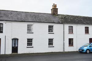 a white house with a blue car parked in front of it at Trekkle Cottage in Gatehouse of Fleet