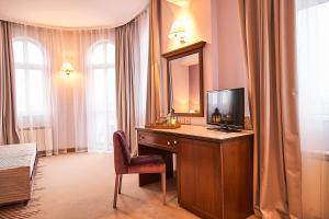a room with a desk with a television and a mirror at Hotel Lion Sofia in Sofia