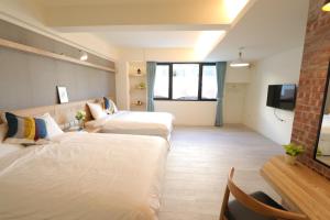 pokój hotelowy z dwoma łóżkami i telewizorem w obiekcie Flora Inn w mieście Anping