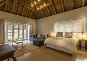 a bedroom with a large bed and a couch at Pierneef's Kraal in Pretoria
