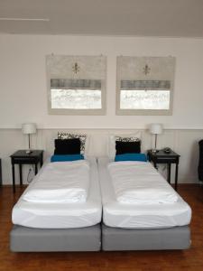 
two beds in a room with a white bedspread at De Doelen in Leiden
