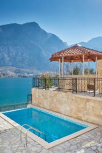 a swimming pool with a balcony overlooking the ocean at Apartments Residence Portofino in Kotor