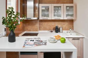 a kitchen with a table with a book and fruit on it at Apartments Residence Portofino in Kotor