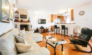uma sala de estar com um sofá branco e cadeiras em Golden view luxury apartment em Maslinica