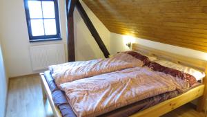 a bed with a wooden frame in a room at chalupa Krkonoše in Háje