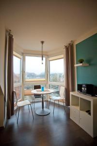 a living room with a table and chairs and windows at Schiller-Quartier 6 in Bremerhaven
