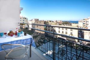 un tavolo e sedie su un balcone con vista di Amore Rentals - Appartamento Erica a Sorrento