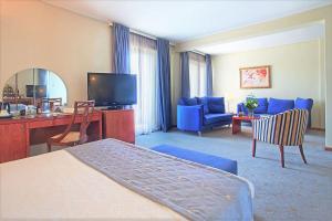 a hotel room with a bed and a desk and a television at Congo Palace in Athens