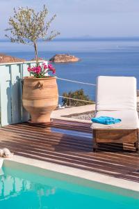 a chair sitting on a deck next to a pool at Theologos Houses in Grikos