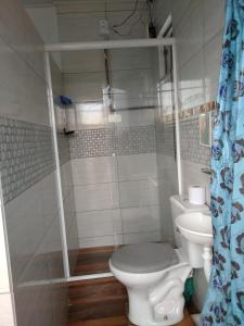 a bathroom with a toilet and a shower at Hospedagem Navegantes in Navegantes