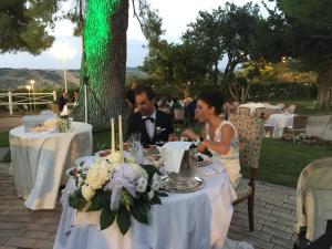 Un uomo e una donna seduti a un tavolo di Hotel Villa Alessandra ad Alanno