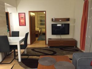 ein Wohnzimmer mit einem TV und einem Esszimmer in der Unterkunft Apartament Wilnianka in Krynica-Zdrój