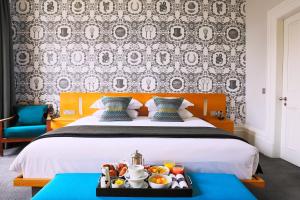 a hotel room with a bed with a tray of food at Malmaison Cheltenham in Cheltenham