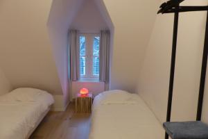 2 camas en una habitación pequeña con ventana en Living The Dream en Gante
