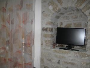 TV de pantalla plana en una pared de piedra en Near the Duomo, en Erice