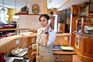 a woman talking on a phone in a restaurant at Landgasthaus Römerhof in Obernburg am Main