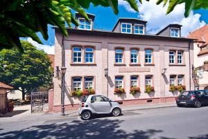 mały samochód zaparkowany przed budynkiem w obiekcie Landgasthaus Römerhof w mieście Obernburg am Main