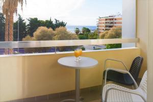 a glass of orange juice sitting on a table in front of a window at Congo Palace in Athens