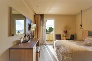 a hotel room with a bed and a desk and a window at Congo Palace in Athens