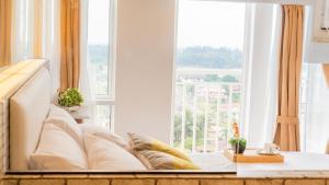 a living room with a couch and a large window at Light and Chic - Tagaytay Vacation Pad in Tagaytay