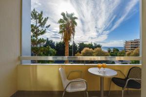 a balcony with a table and chairs and a large window at Congo Palace in Athens