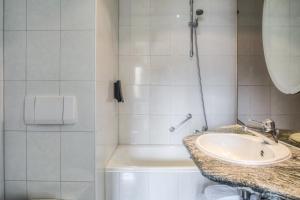 a bathroom with a sink, toilet, and bathtub at Hotel Kasteel Doenrade in Doenrade