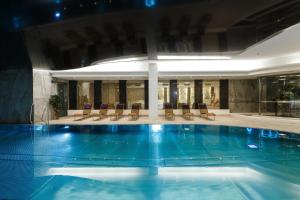 uma grande piscina num edifício com cadeiras em Hotel Thermal em Karlovy Vary