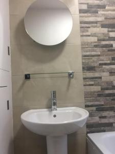 een badkamer met een witte wastafel en een spiegel bij Modern Luxury Central Apartment in Birmingham
