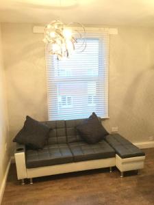 a couch sitting under a window in a room at Modern Luxury Central Apartment in Birmingham