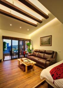 uma sala de estar com um sofá e uma mesa em The Sunbeam Hideaway B&B em Luodong