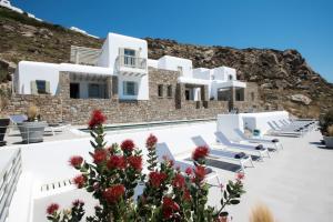 a row of chairs and flowers in front of a building at Tourlos Bay Villas Mykonos in Tourlos