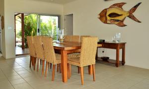 uma sala de jantar com uma mesa de madeira e cadeiras em Banfields Retreat em Mission Beach