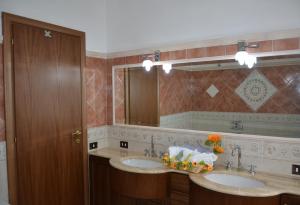 a bathroom with two sinks and a large mirror at Casa del Girasole in Genazzano