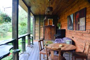 a wooden porch with a wooden table and chairs at Gallery Guest Rooms in Kernavė