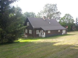 een bruin huis met een zwart dak op een veld bij Horska chata Kristynka in Kořenov