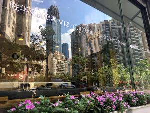 a window view of a city with buildings and flowers at VIZ Culture & Arts Apartment in Nanning