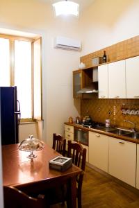 une cuisine avec une table en bois et une salle à manger dans l'établissement I Sorrisi Di Napoli, à Naples