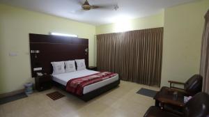 Pokój hotelowy z łóżkiem i krzesłem w obiekcie Grand Beach Resort w mieście Koks Badźar