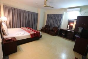 pokój hotelowy z łóżkiem i telewizorem w obiekcie Grand Beach Resort w mieście Koks Badźar