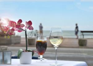 セント・レオナルズにあるSt Leonards Seaside Apartmentの海の景色を望むテーブルの上にワイン2杯