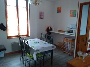 a kitchen with a table with chairs and a microwave at FLAB'ZEN in Criel-sur-Mer