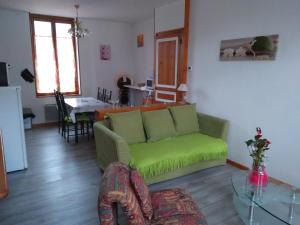 a living room with a green couch and a table at FLAB'ZEN in Criel-sur-Mer